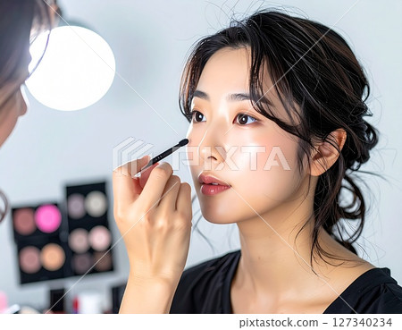 A makeup artist applying eyeliner to a model 1 AI-generated image 127340234
