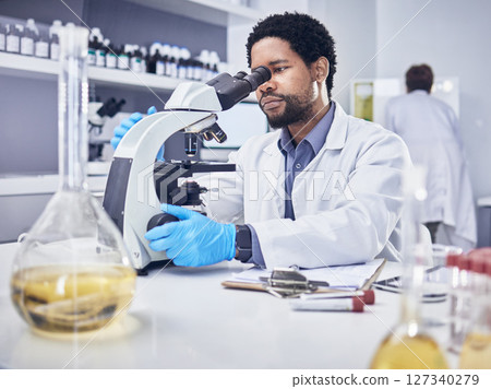 Microscope, scientist and black man with research, healthcare and diagnosis in laboratory. Science, African American male and lab equipment for cure, check sample for illness, virus and innovation. Microscope, scientist and black man with research, healthcare and diagnosis in laboratory. Science, African American male and lab equipment for cure, check sample for illness, virus and innovation. 127340279