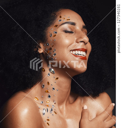 Woman face, body art jewels or diamond rhinestones on black background studio in fashion sparkle, festival accessory or creative party crystals. Happy smile, makeup beauty model or skin cosmetic gems 127340281