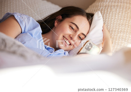 Phone, bed and relax woman typing post to social media app, online blog or doing internet web search. Bedroom, networking communication or gen z girl reading meme, news or contact social network user 127340369