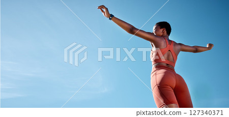 Woman, arms up or fitness success on blue sky background in workout, training or exercise goals for healthcare or cardiovascular wellness. Low angle runner, sports athlete or hands raised with mockup Woman, arms up or fitness success on blue sky background in workout, training or exercise goals for healthcare or cardiovascular wellness. Low angle runner, sports athlete or hands raised with mockup 127340371