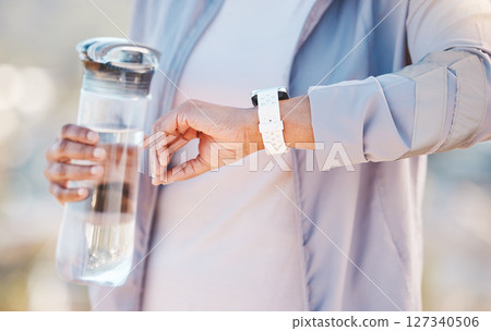 Water bottle, fitness and smartwatch with woman runner outdoor, cardio and wellness with time or steps progress check. Hand, smart watch and training, workout and running with wellness and sport 127340506
