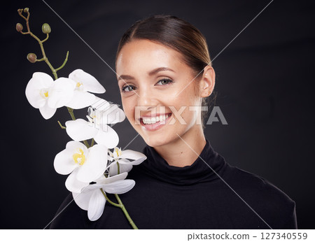 Woman with flower, beauty and face, nature and skincare, natural and cosmetic care with facial treatment against studio background. Black, dark and orchid with microblading, healthy skin and portrait Woman with flower, beauty and face, nature and skincare, natural and cosmetic care with facial treatment against studio background. Black, dark and orchid with microblading, healthy skin and portrait 127340559