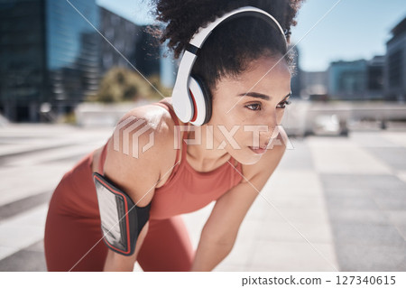 Phone, fitness app and headphones, tired black woman runner stop to relax or breathe on city workout run. Health, urban training and wellness, woman on break from running exercise and streaming music 127340615