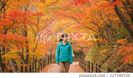 一個女人享受秋天的落葉 127340720