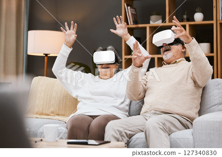 Gaming, virtual reality and senior couple with headset play online game with VR, technology and smile. Future, elderly woman and happy man in home watching futuristic augmented reality video on sofa. 127340830