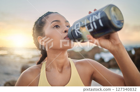Health, fitness and woman drinking water at beach after running, exercise or workout. Sports, hydration and thirsty female athlete with water bottle on break after training for wellness at sunset. 127340832