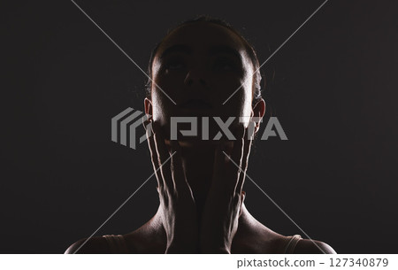 Woman, beauty and face silhouette in dark fantasy, cosmetics and dream aesthetics. Shadow, black background and model headshot while touching facial skin in mystery, studio background and erotic body 127340879