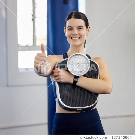 Woman, gym portrait and thumbs up with scale, wellness and weight loss goal for health, body or fitness. Girl, healthy and workout to lose weight, exercise or focus on anatomy, self care or happiness Woman, gym portrait and thumbs up with scale, wellness and weight loss goal for health, body or fitness. Girl, healthy and workout to lose weight, exercise or focus on anatomy, self care or happiness 127340904