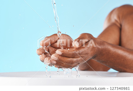 Water splash, hands and cleaning with beauty and black man, hygiene zoom and hydration with water mockup. Clean water drops, splash and skincare with natural cosmetics against blue studio background Water splash, hands and cleaning with beauty and black man, hygiene zoom and hydration with water mockup. Clean water drops, splash and skincare with natural cosmetics against blue studio background 127340981