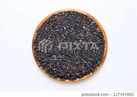 Black sesame seed in wooden bowl on white background, Food ingredient, Top view Black sesame seed in wooden bowl on white background, Food ingredient, Top view 127341002