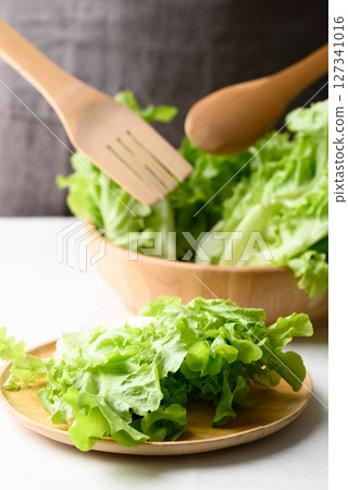 Organic green oak lettuce on wooden plate and bowl, Fresh vegetable, Healthy eating 127341016