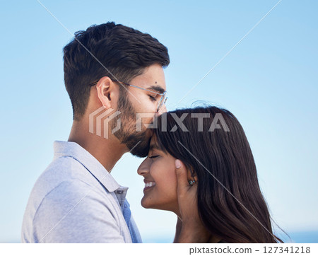 Couple, forehead kiss and love outdoor with commitment, trust and happy together with bonding and care. Date, romance and relationship with young man, woman profile and smile against sky background Couple, forehead kiss and love outdoor with commitment, trust and happy together with bonding and care. Date, romance and relationship with young man, woman profile and smile against sky background 127341218