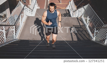Urban fitness, man running on stairs and listening to music on headphones on outdoor exercise in Los Angeles. Health, motivation and a California city runner on steps for marathon training in morning Urban fitness, man running on stairs and listening to music on headphones on outdoor exercise in Los Angeles. Health, motivation and a California city runner on steps for marathon training in morning 127341251