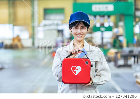 Female worker with AED at factory 127341290