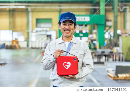 Male worker with AED at factory 127341291