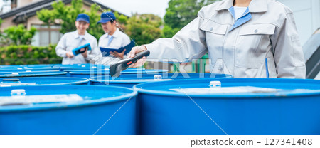 A female worker scans luggage using a handheld terminal 127341408