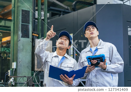 A group of workers inspecting a factory A group of workers inspecting a factory 127341409