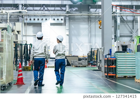 Rear view of a group of workers walking through a factory Rear view of a group of workers walking through a factory 127341415