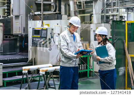 工廠裡一群工人使用平板電腦工作 127341419