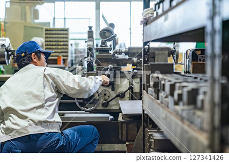 Worker operating machine tools in a factory 127341426
