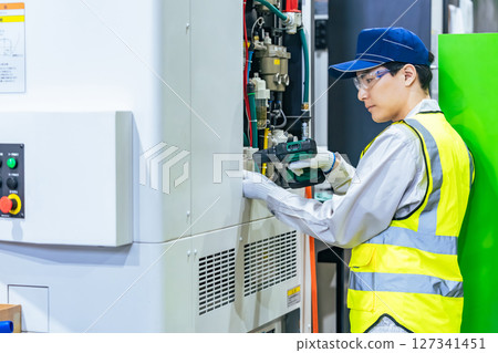 一名工人在工廠維護工具機 127341451