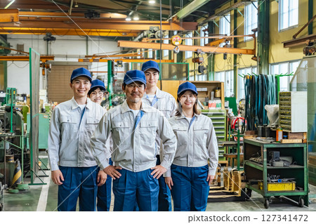 Group photo of a group of workers standing in a factory Group photo of a group of workers standing in a factory 127341472