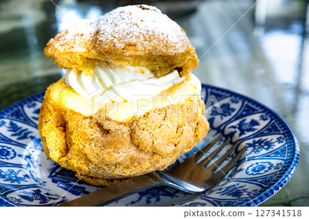 Delicious cream puffs filled with fresh cream and custard cream Delicious cream puffs filled with fresh cream and custard cream 127341518