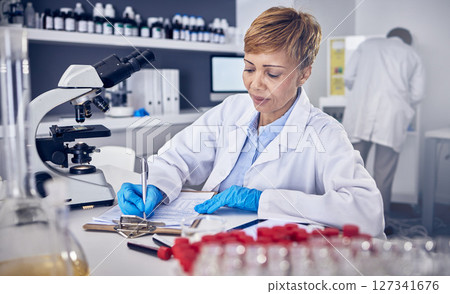Senior black woman, research or scientist writing a science report in a laboratory for medical data analysis. Healthcare, focus or doctor working on chemistry paperwork, documents or development 127341676