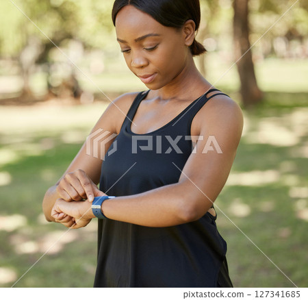 Time, fitness or black woman in nature with a smartwatch to monitor heart health in training, exercise or park workout. Wellness, digital or girl runner checking running performance stats in Nigeria Time, fitness or black woman in nature with a smartwatch to monitor heart health in training, exercise or park workout. Wellness, digital or girl runner checking running performance stats in Nigeria 127341685