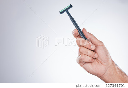 Grooming, shaving and hand with a razor for body hair, hygiene and clean shave on a studio background with mockup. Cleaning, equipment and model with a product for trimming hairs for wellness 127341701