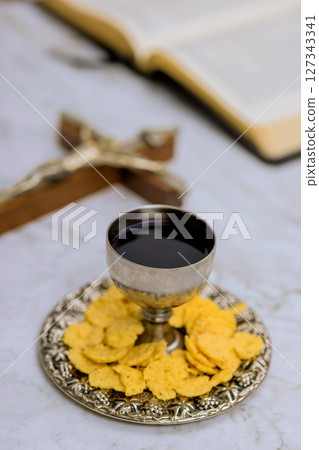 Communion elements including wine bread are thoughtfully arranged on silver tray, creating peaceful atmosphere in church Communion elements including wine bread are thoughtfully arranged on silver tray, creating peaceful atmosphere in church 127343341