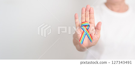 Elderly with LGBTQ Rainbow ribbon for concept of June Pride month, April Autism Awareness, All cancer Awareness, February World Cancer day, October World Hospice and Palliative care day and Survivor Elderly with LGBTQ Rainbow ribbon for concept of June Pride month, April Autism Awareness, All cancer Awareness, February World Cancer day, October World Hospice and Palliative care day and Survivor 127343491