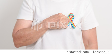 Elderly with LGBTQ Rainbow ribbon for concept of June Pride month, April Autism Awareness, All cancer Awareness, February World Cancer day, October World Hospice and Palliative care day and Survivor 127343492
