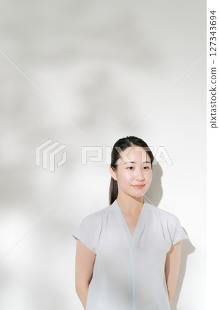 A woman in her twenties smiling in the summer sunshine A woman in her twenties smiling in the summer sunshine 127343694
