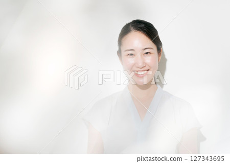 A woman in her twenties smiling in the summer sunshine A woman in her twenties smiling in the summer sunshine 127343695