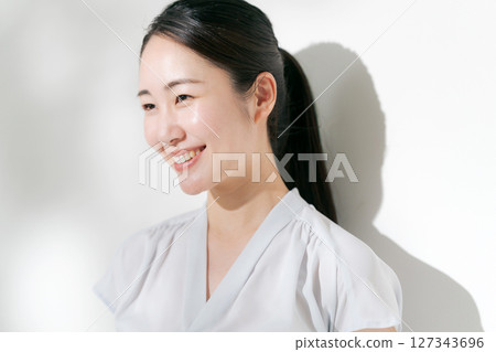 A woman in her twenties smiling in the summer sunshine A woman in her twenties smiling in the summer sunshine 127343696
