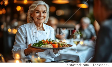 Smiling Chef Presents Gourmet Dish in Warmly Lit Restaurant Sett 127344359