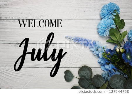 Welcome July text with blue flowers bouquet decoration on wooden background Welcome July text with blue flowers bouquet decoration on wooden background 127344768