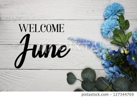 Welcome June text with blue flowers bouquet decoration on wooden background Welcome June text with blue flowers bouquet decoration on wooden background 127344769