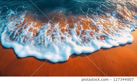Ocean Wave Crest on Warm Sandy Beach at Sunset 127344807
