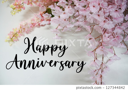 Happy Anniversary text with flowers decorations on wooden background 127344842