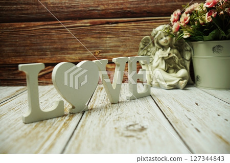 Valentine's day background concept with LOVE letters and flowers decoration on wooden background 127344843