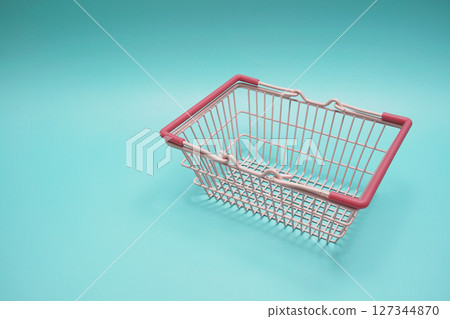 Pink empty shopping basket with space copy on blue background 127344870