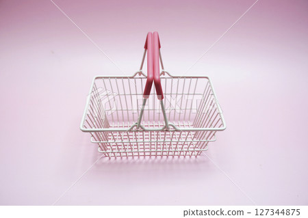 Pink empty shopping basket with space copy on pink background 127344875