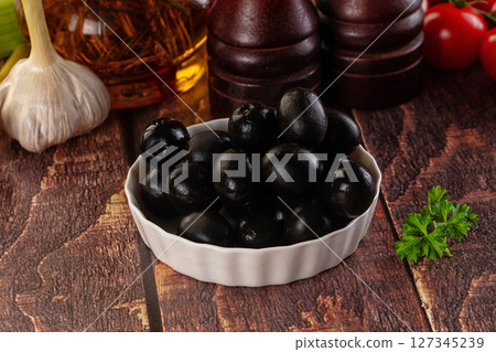 Mediterranean marinated Black olives in the bowl 127345239