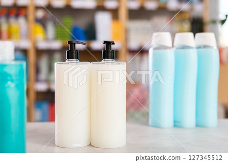 Shelf lined up with shampoo, shower gel, liquid hand soap 127345512