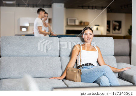 Young girl choosing convenient sofa in furniture shop Young girl choosing convenient sofa in furniture shop 127345561