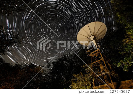 Satellite Dish Under Star Trails at Night 127345627