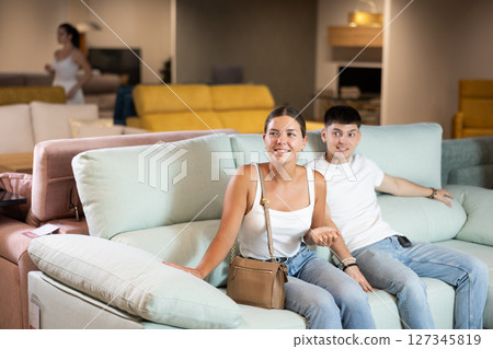 Young couple choosing convenient sofa in furniture shop 127345819